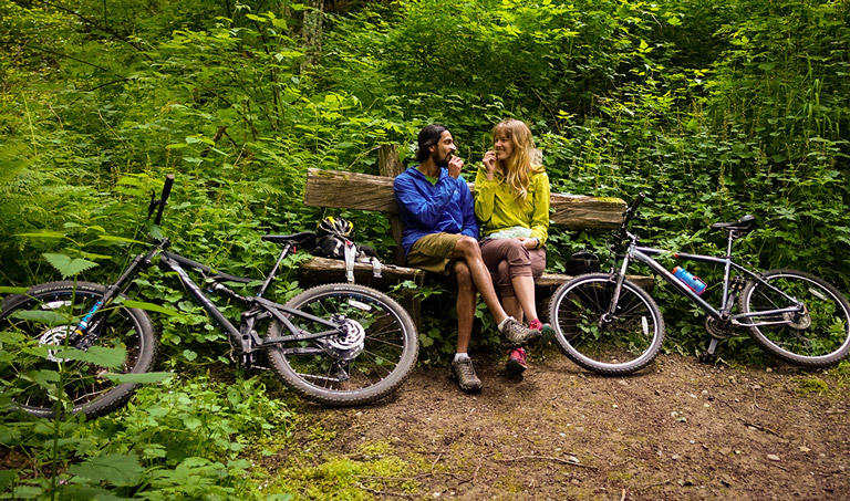 Sujay and Violet sitting in forest with bikes nearby